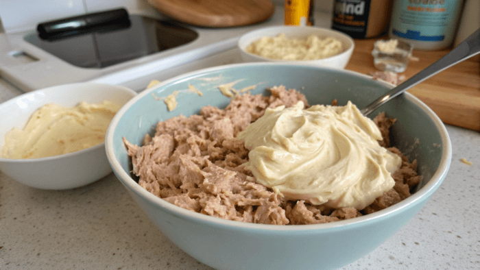 Mixing tuna with mayonnaise in a bowl
