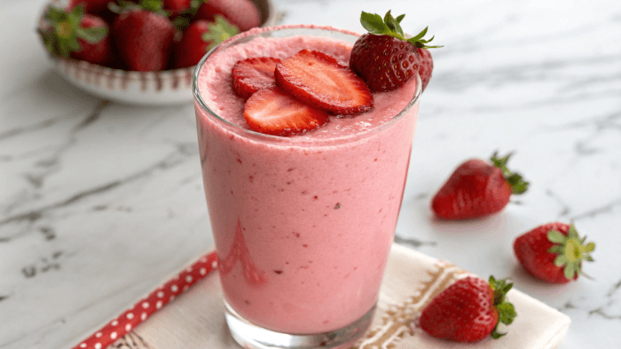 Fresh strawberry smoothie in a glass with bright pink color